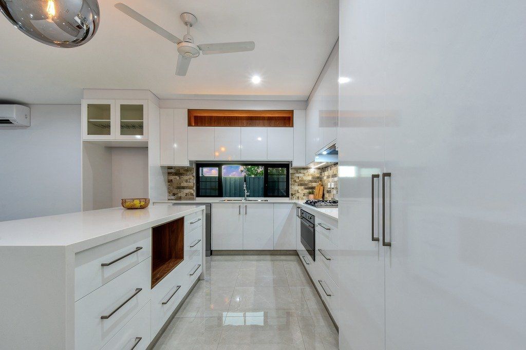 A kitchen with white cabinets and a ceiling fan.