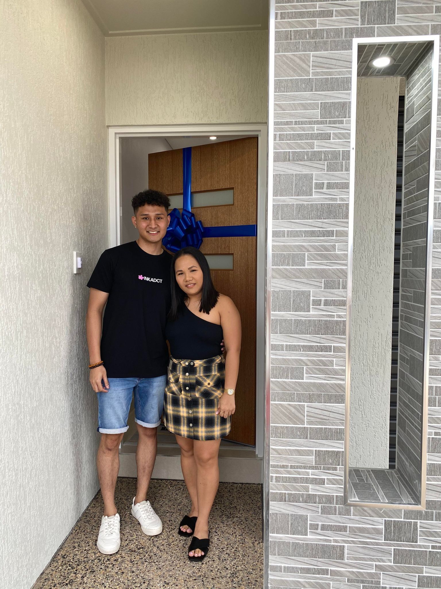 A man and a woman are standing in front of a door.