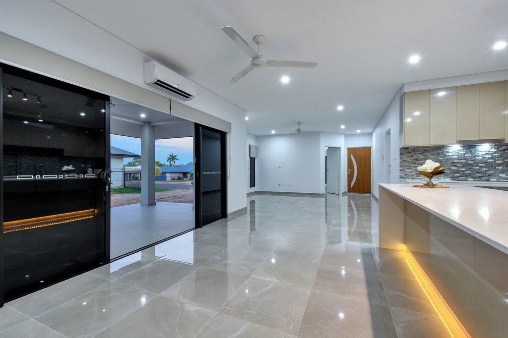 A large empty room with a ceiling fan and sliding glass doors leading to a patio.