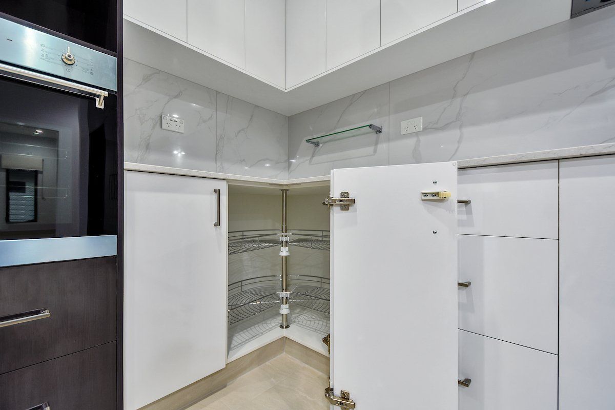 A kitchen with white cabinets and a stainless steel oven.