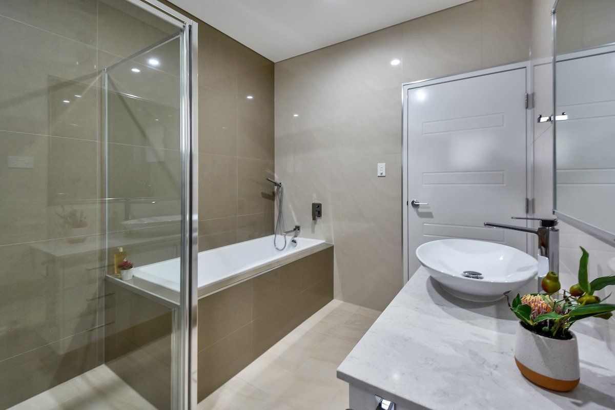 A bathroom with a bathtub , sink , and shower.