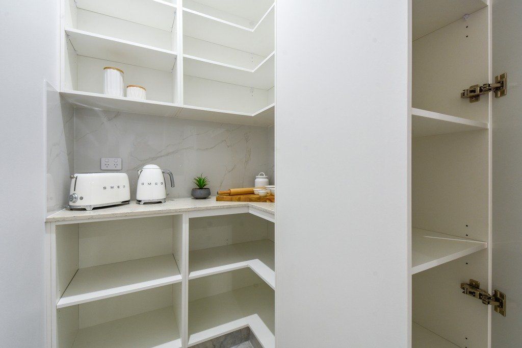 A pantry with empty shelves and a toaster oven.