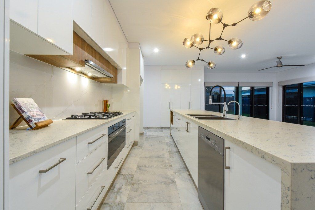 A kitchen with white cabinets , stainless steel appliances , and granite counter tops.