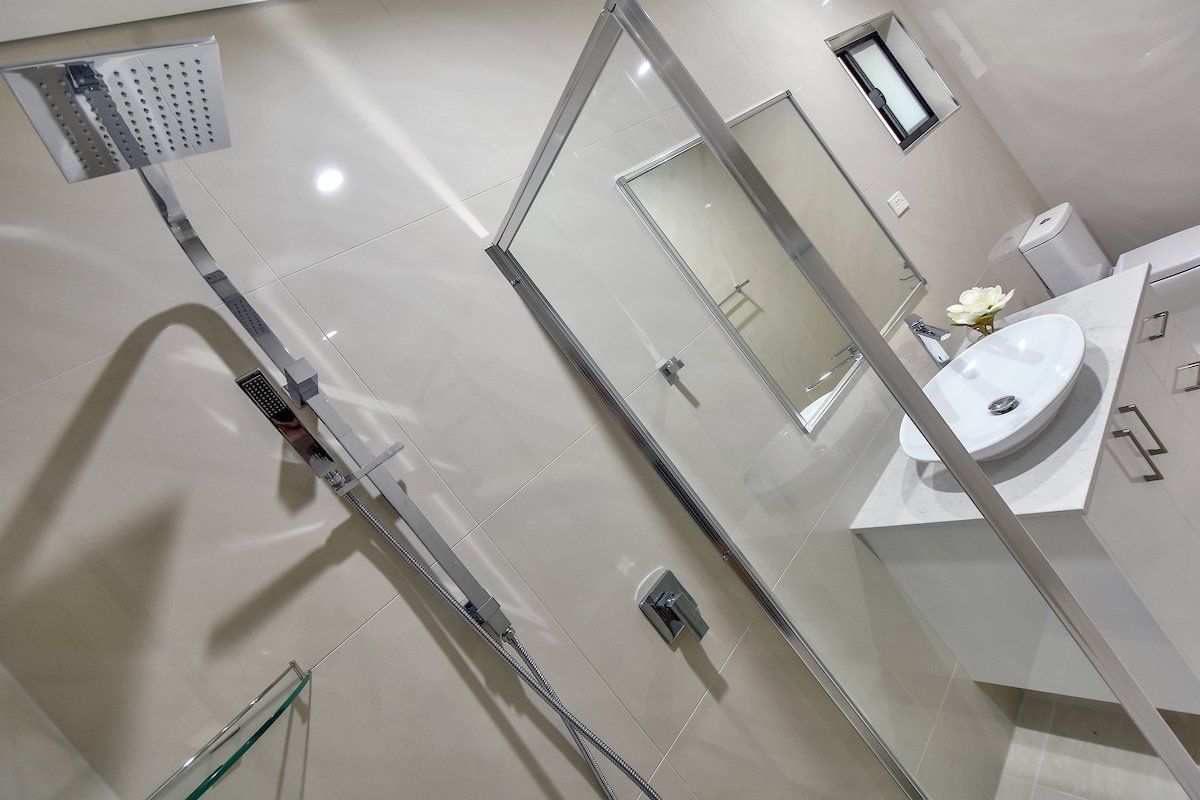 A bathroom with a sink , shower and mirror