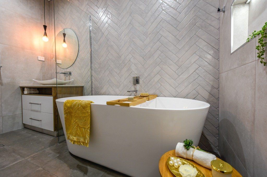 A bathroom with a bathtub , sink , mirror and shower.