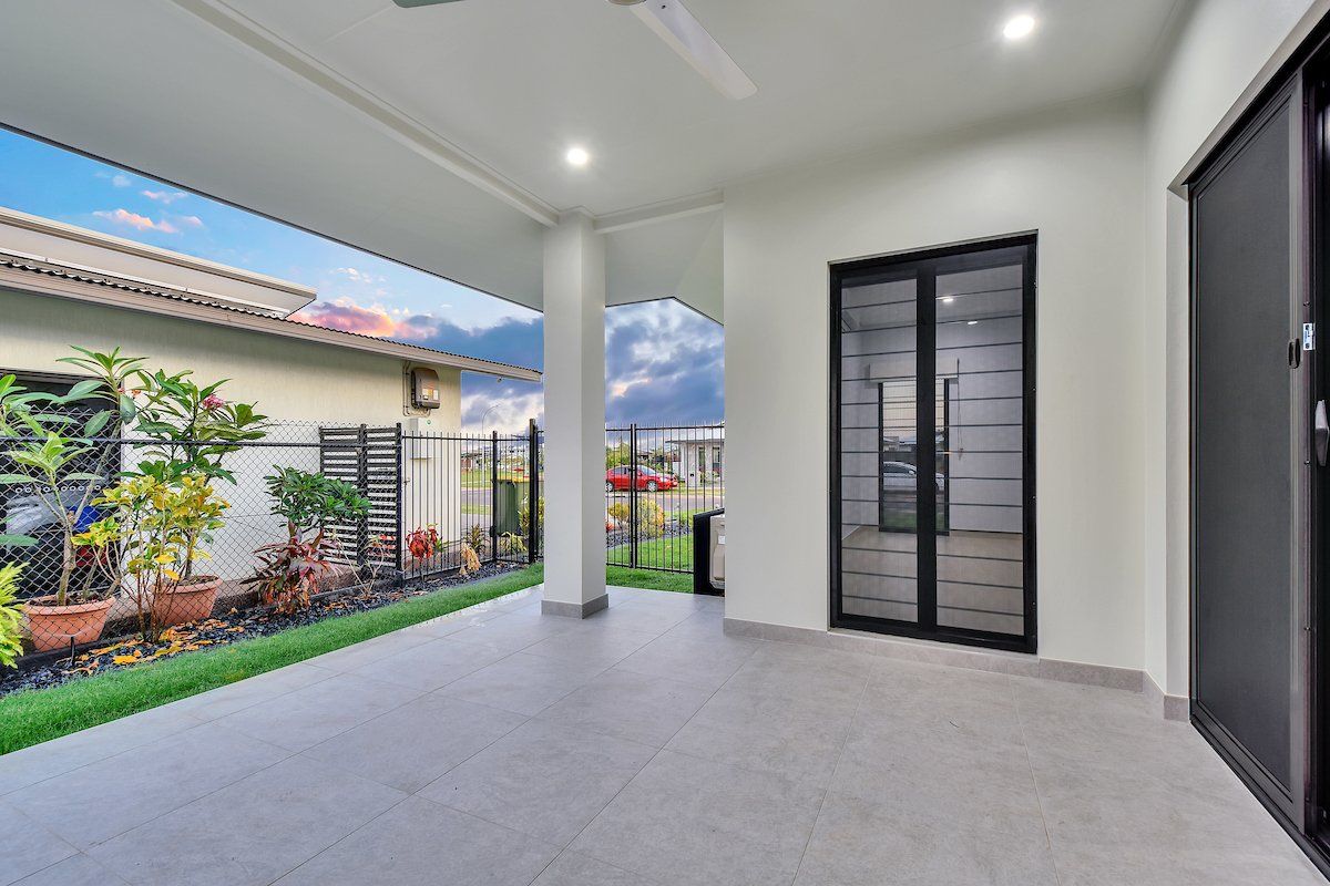 A patio with sliding glass doors and a ceiling fan in a house.