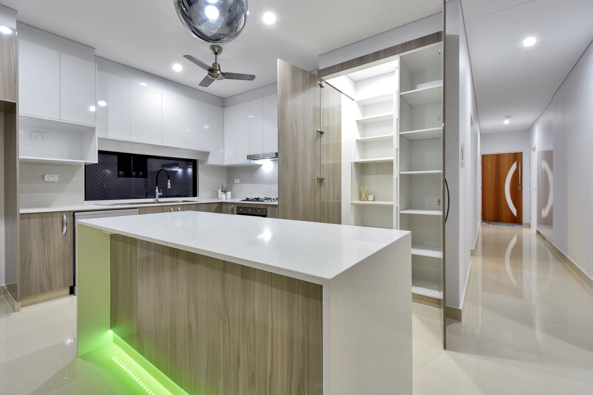 A kitchen with a large island and a ceiling fan.