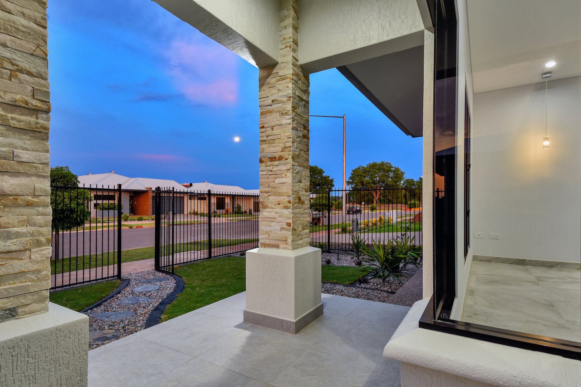 A porch with a fence and a view of a house