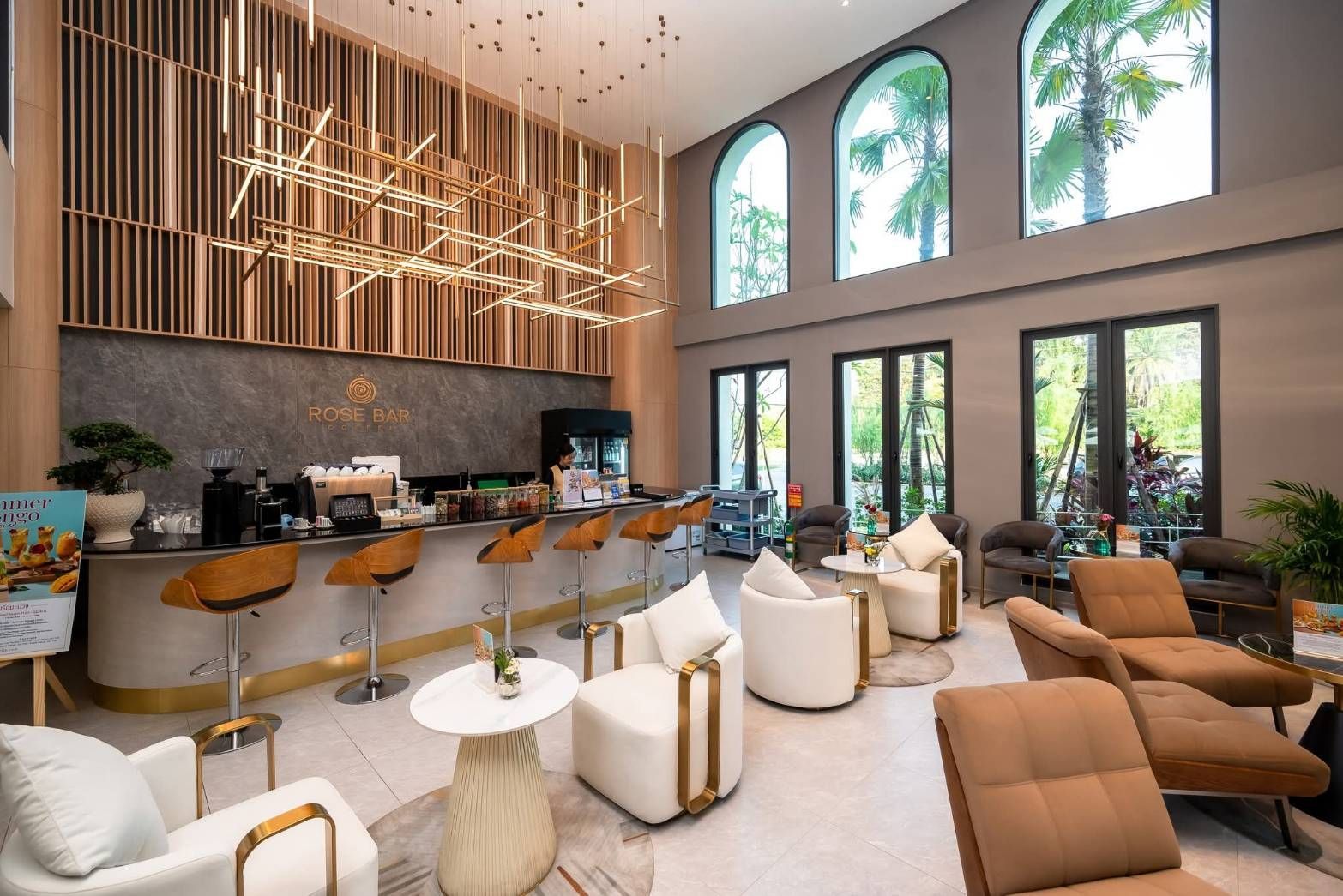 Modern hotel lobby lounge with high ceilings, bar seating, and warm wood accents by large windows.