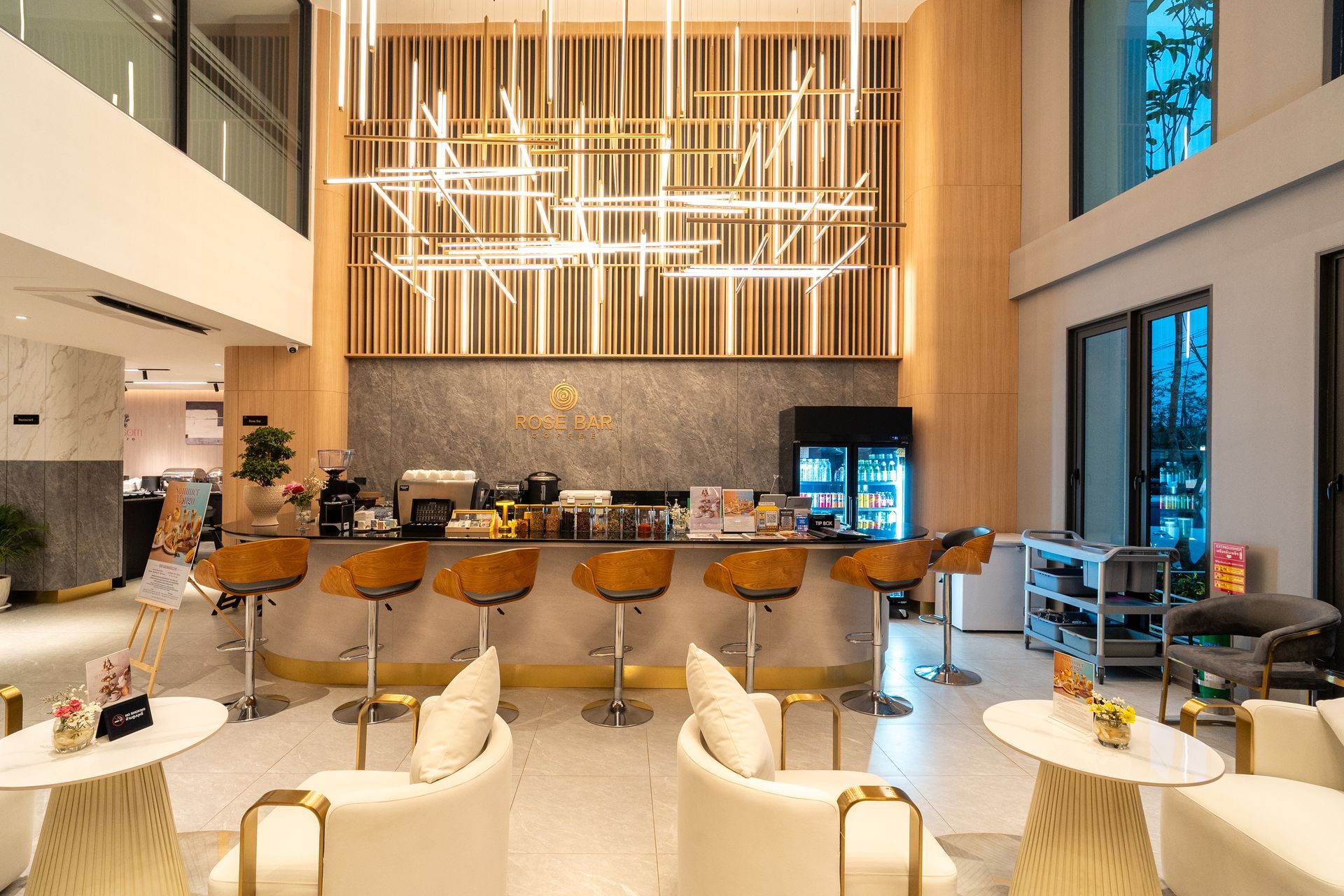 Modern hotel lobby bar with high stools, lounge chairs, and warm pendant lighting
