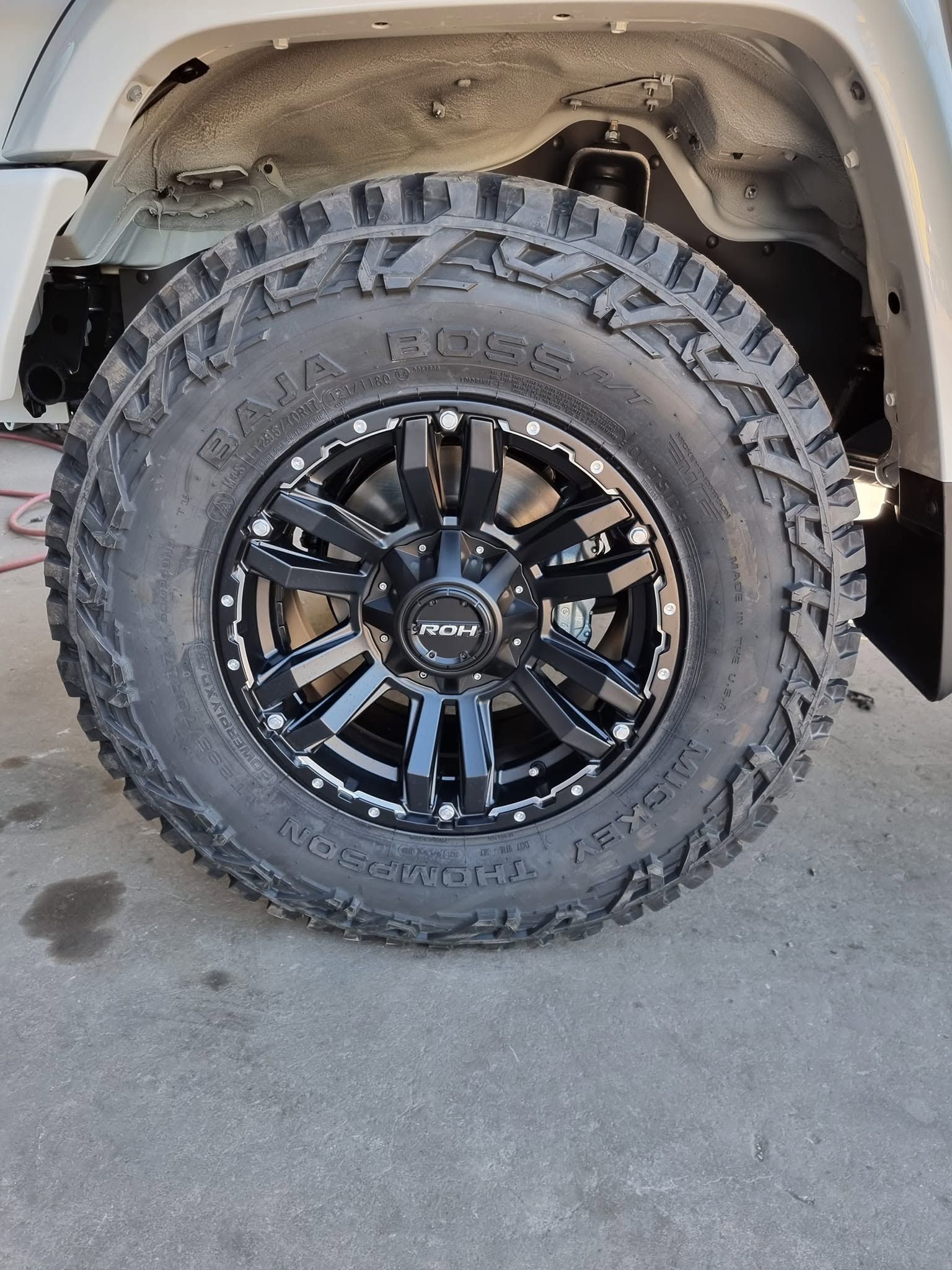 Lifted Truck Wheel with Black Off-road Tire and Black Rim Under the Fender — Goodyear Autocare Bowen in Bowen, QLD