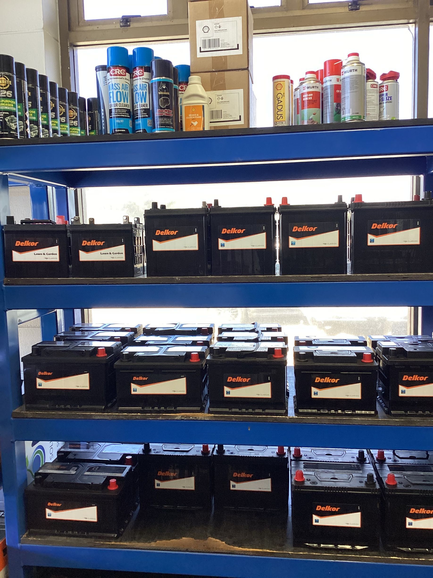 A Mechanic Is Working On A Car Battery In A Garage — Goodyear Autocare Bowen in Bowen, QLD
