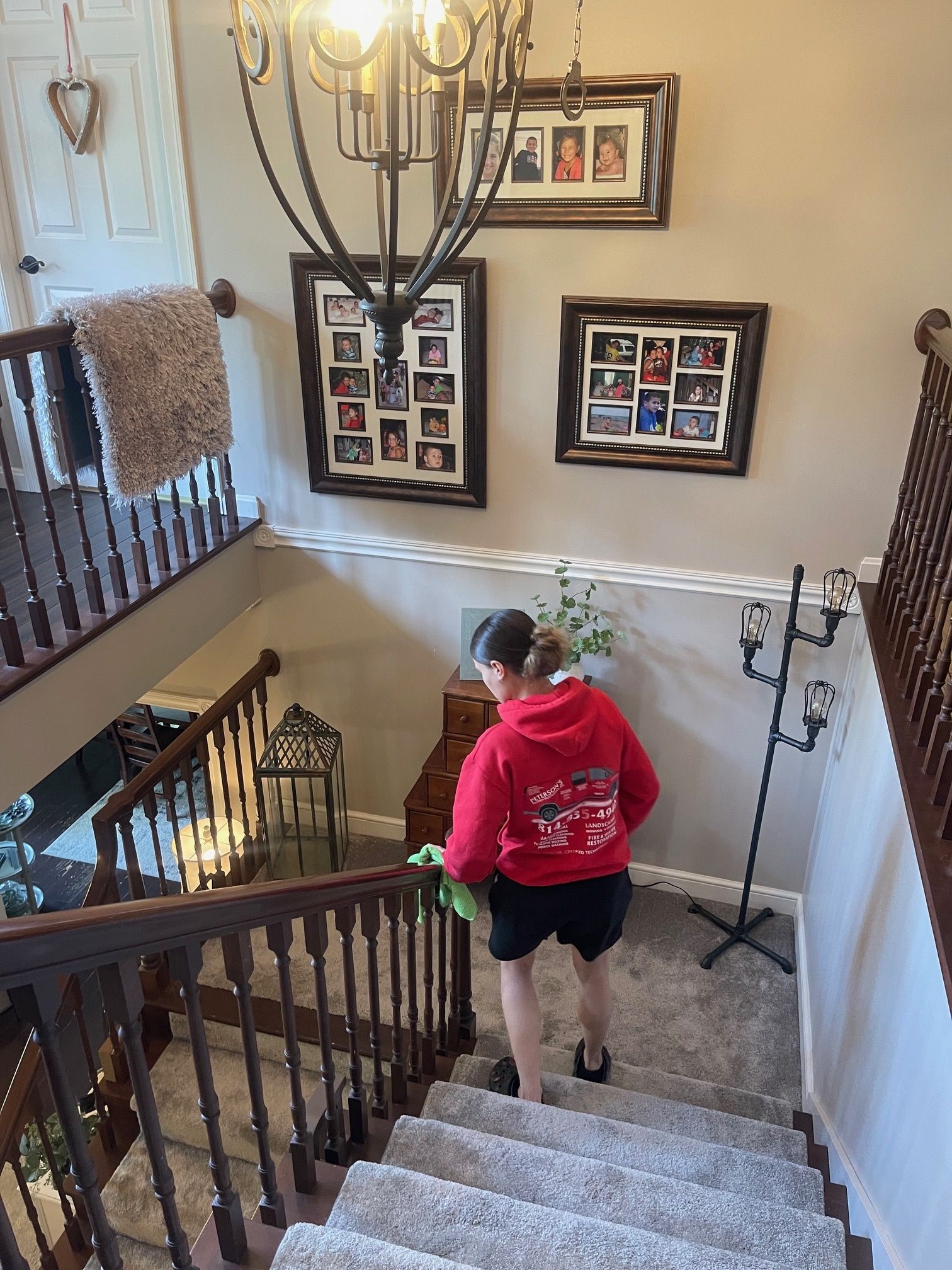 A woman is cleaning the railing of a staircase in a house. — Erie, PA — Peterson’s Property Maintenance