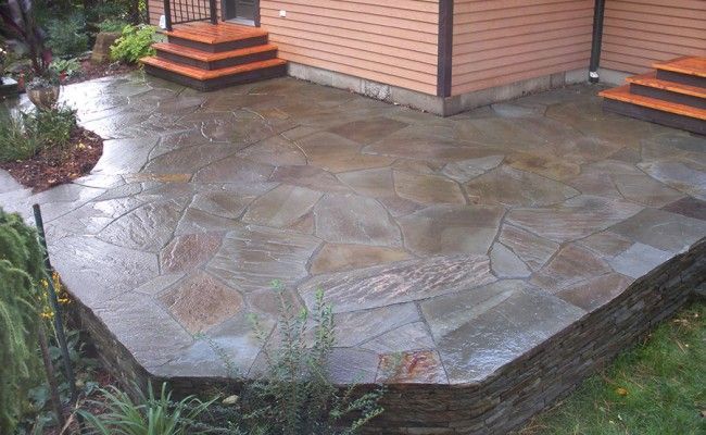 Terrasse en béton imprimé humide à côté d'une maison avec des marches et un revêtement rose