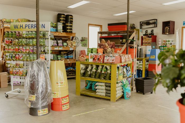 Une allée lumineuse de supérette avec des étagères remplies de snacks, de boissons et de produits ménagers.