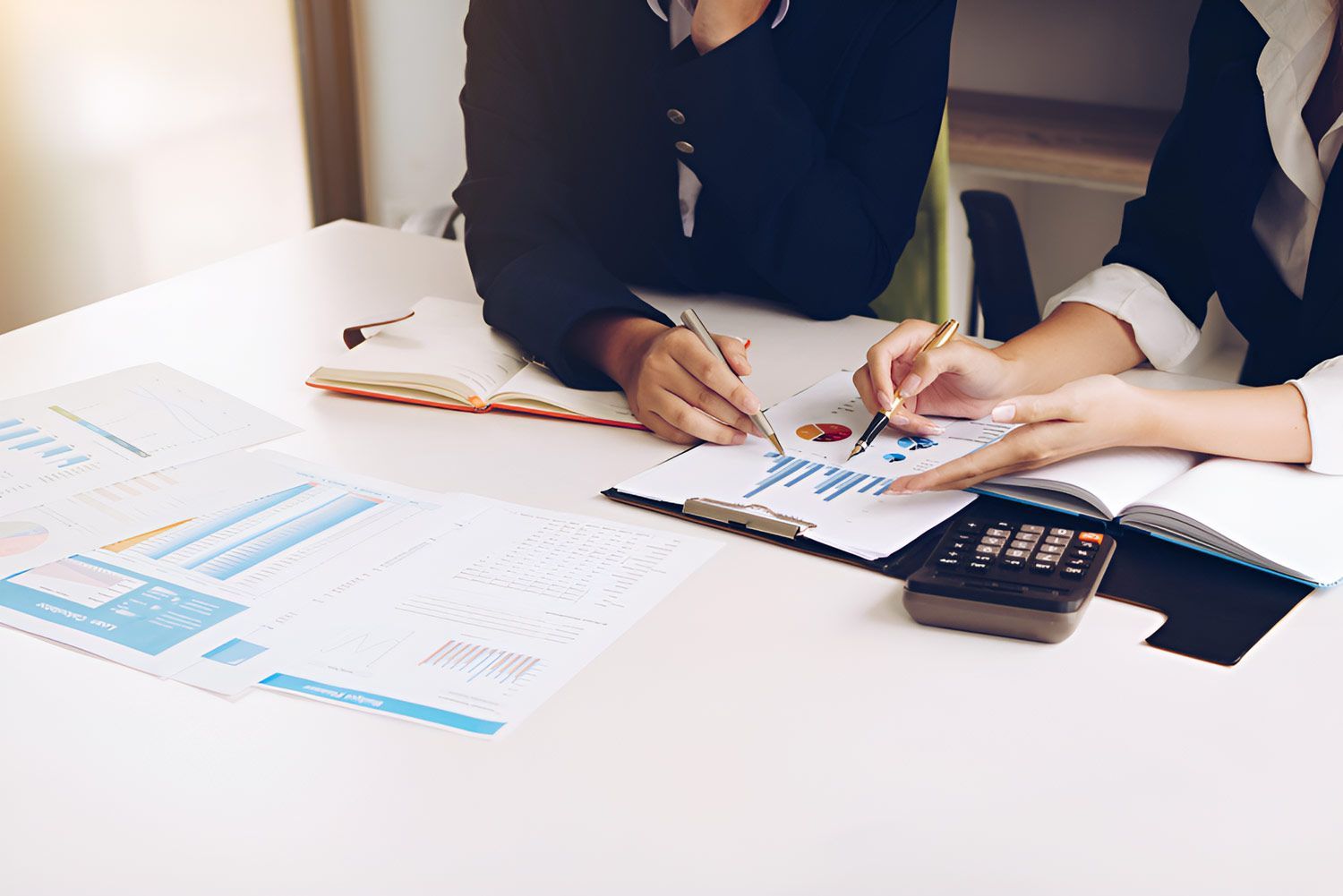 Two Women Hand Pointing At Finance Chart — Whitson Dawson Accountants in North Queensland