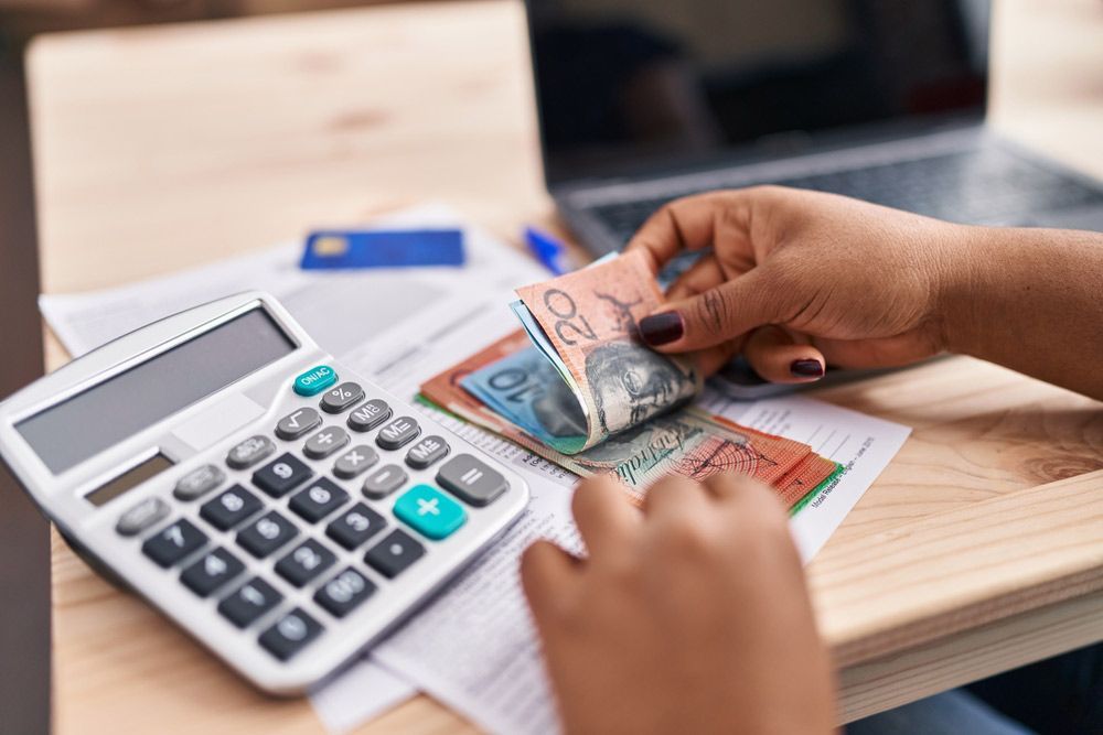 Accountant Using Calculator Counting Australian Dollars — Whitson Dawson Accountants in North Whitsundays, Queensland