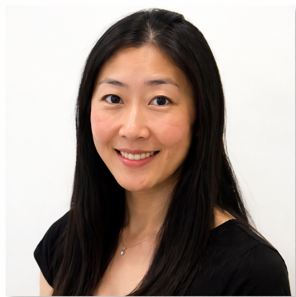 Smiling woman with long black hair wearing a black top against a white background