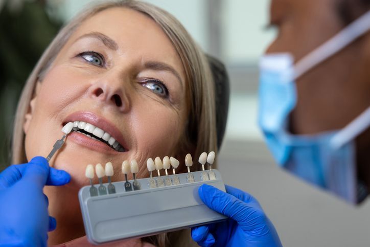 Dentist fitting tooth shade guide to a patient in a clinic