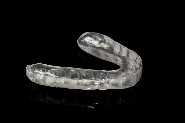 Clear tooth aligner on black background