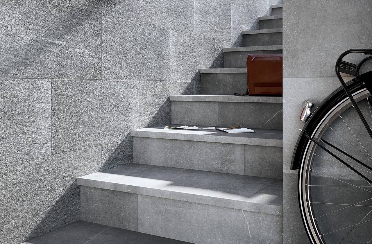Scala in pietra grigia con una valigetta e una ruota di bicicletta visibili.