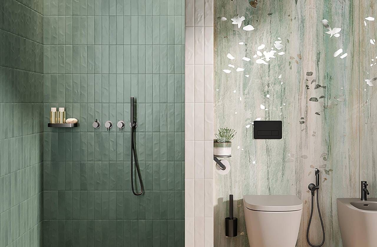 Doccia e WC piastrellati di verde con carta da parati ispirata alla natura in un bagno moderno.