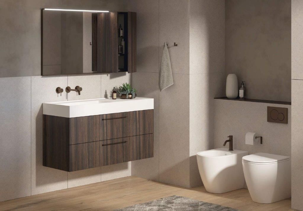 Bagno moderno con mobile lavabo in legno scuro, piano di lavoro bianco e bidet.