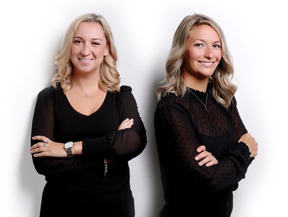 Two women standing next to each other with their arms crossed