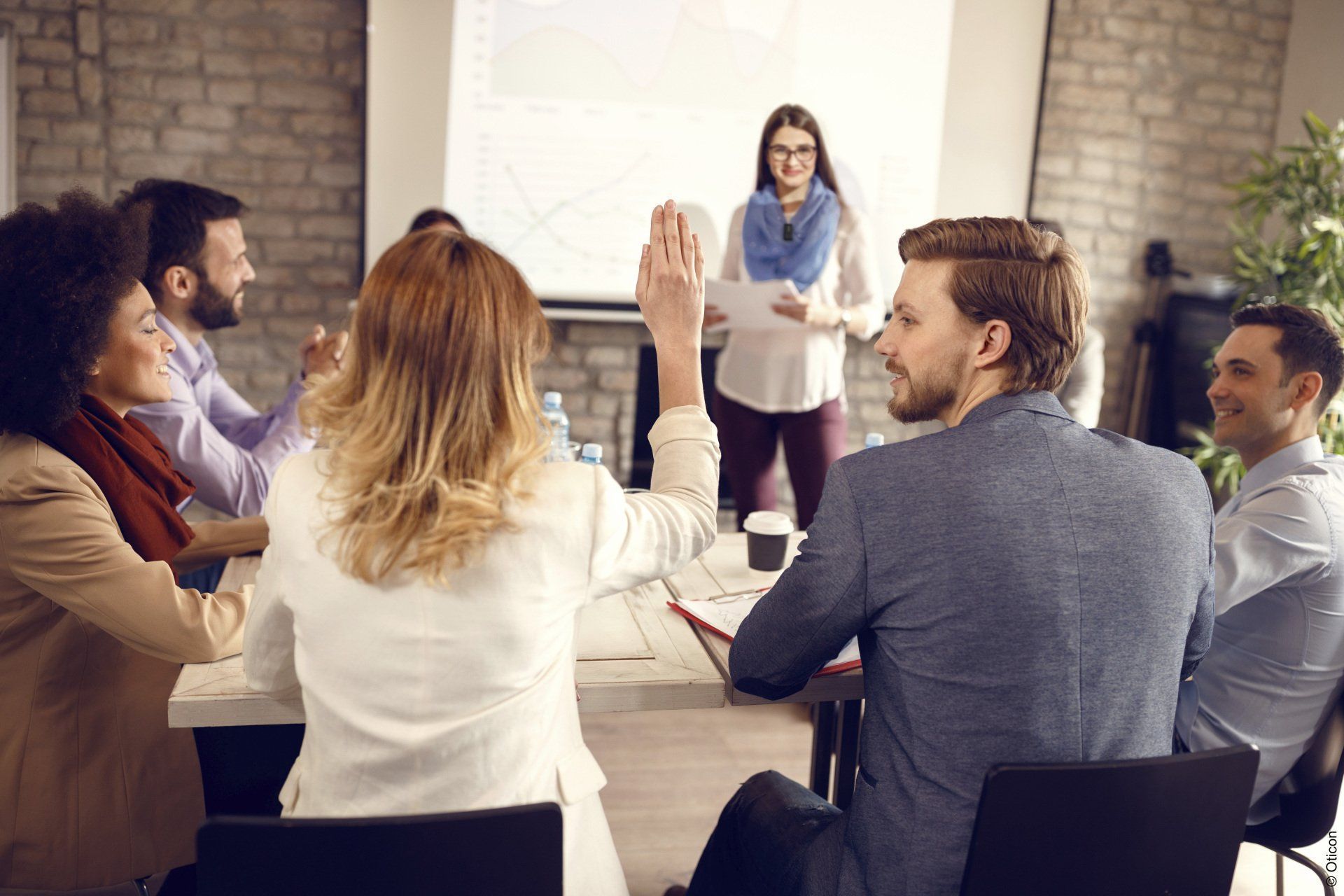Un groupe de personnes sont assises autour d'une table et se font un high five.