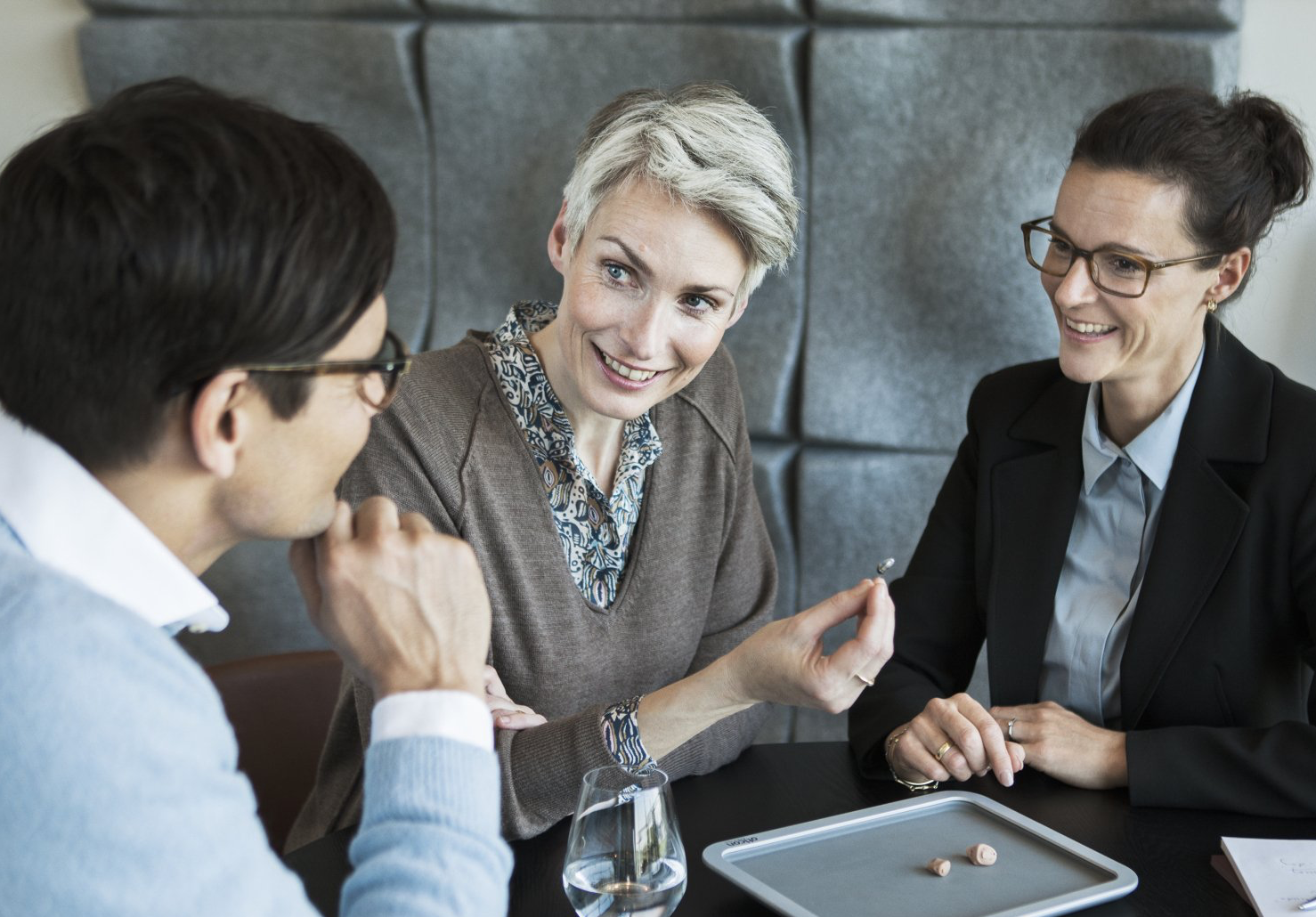 Un groupe de personnes sont assises à une table et discutent entre elles.