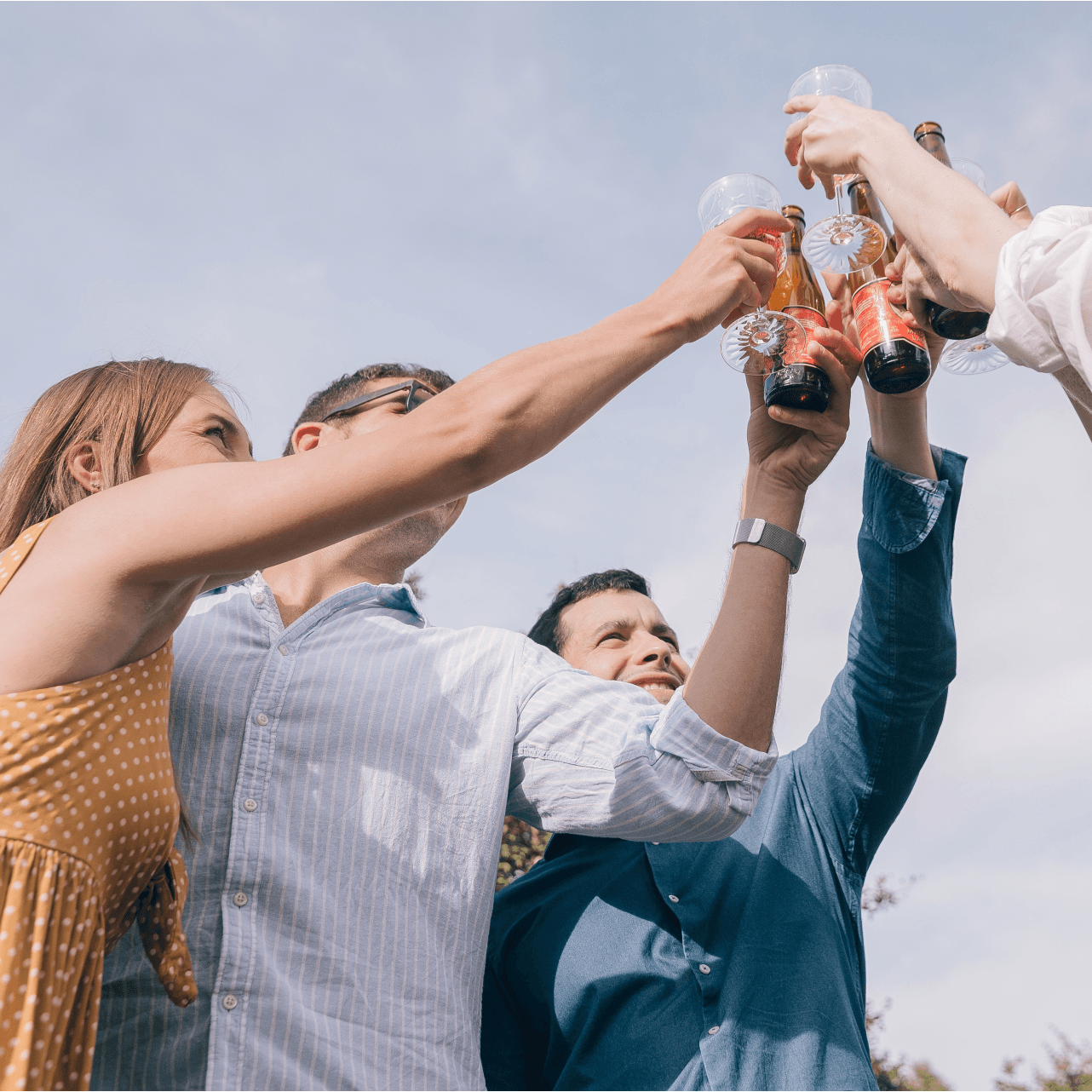 A group of people are raising their glasses in the air.
