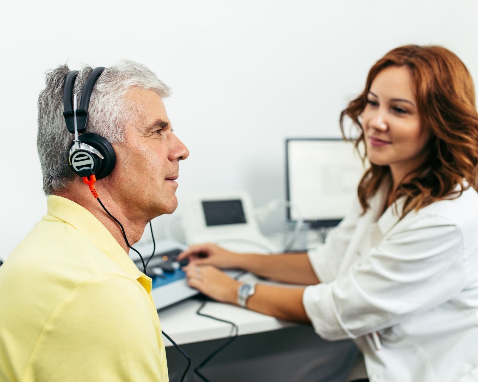 A man wearing headphones is being examined by a doctor.