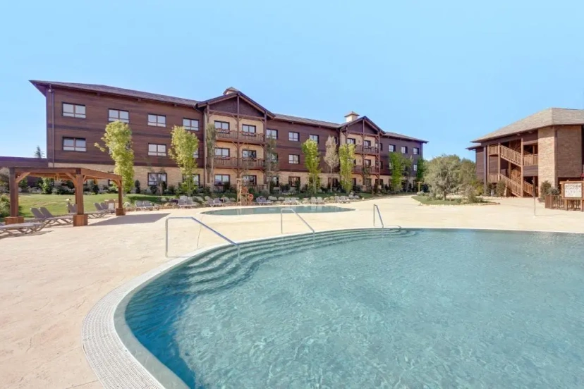 Apartment complex with a pool and courtyard under a clear sky