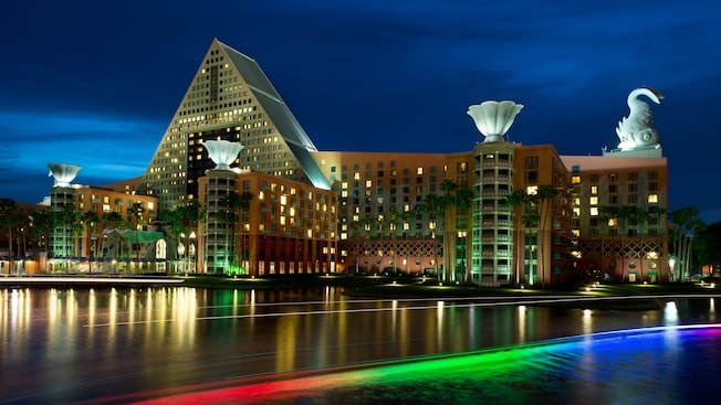Nighttime city waterfront with illuminated modern buildings and colorful reflections on the water
