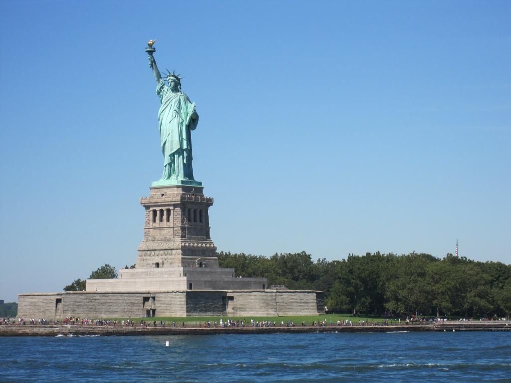 The statue of liberty is in the middle of a body of water