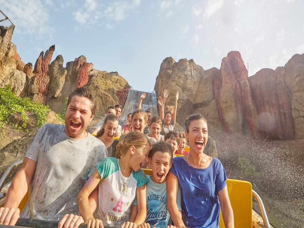 A family is riding a roller coaster at a theme park.