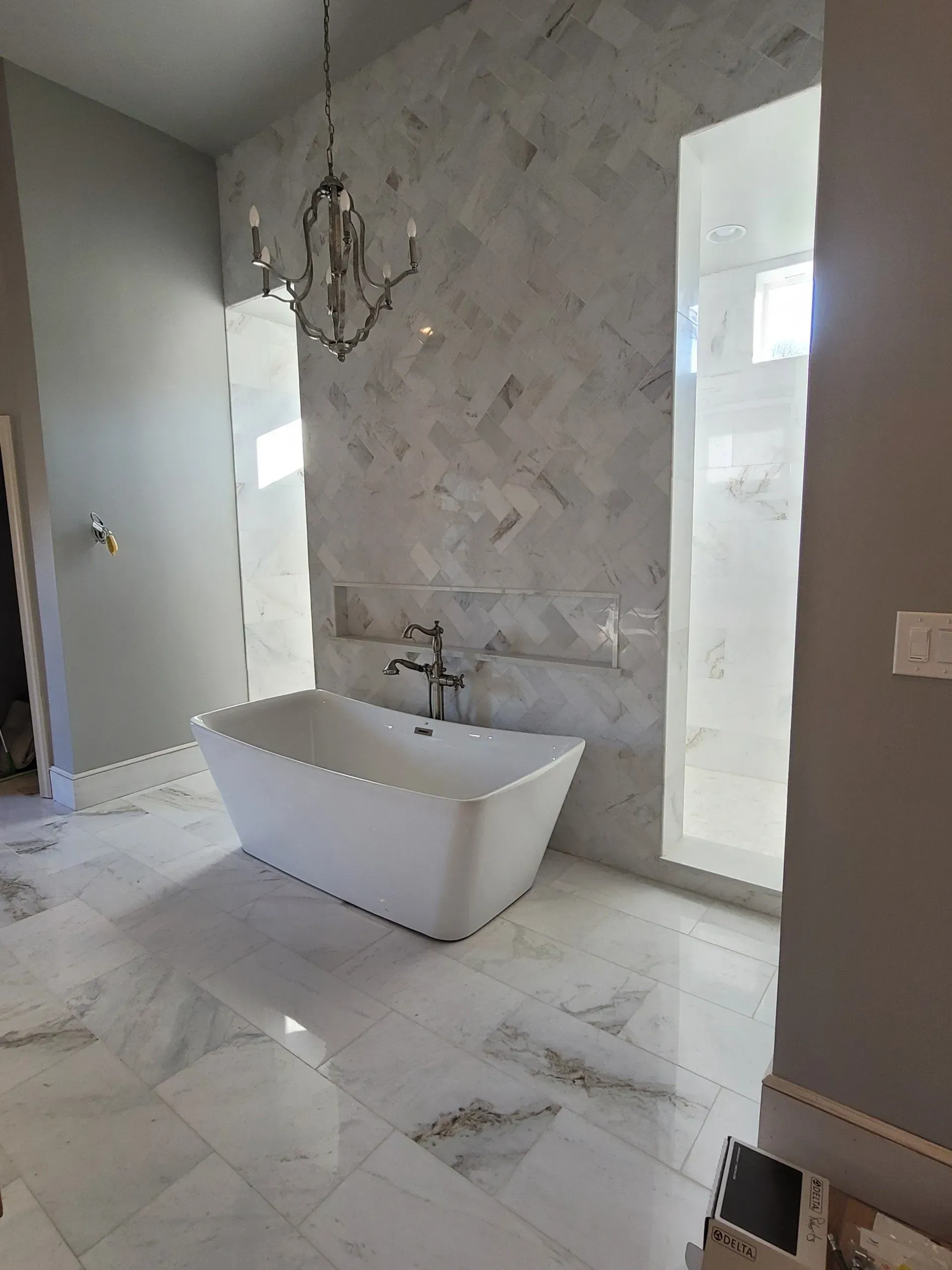 Bright white bathroom with double vanity, bathtub, and black accents.