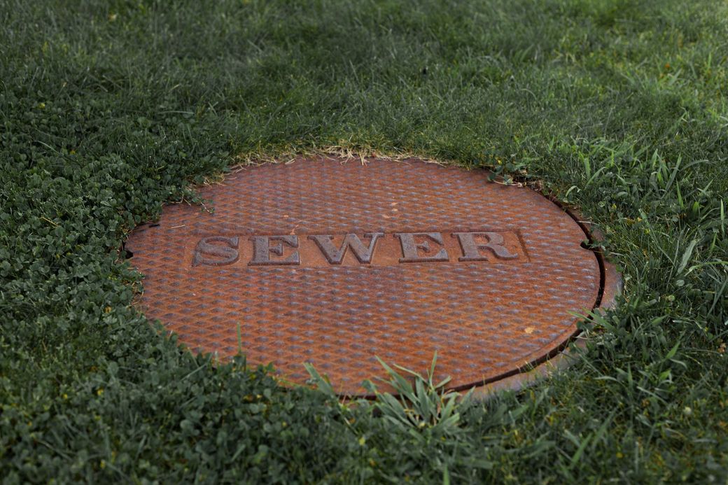 Round orange manhole cover labeled 