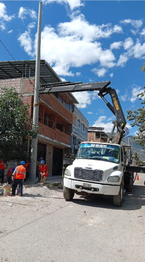 Obra en construcción con grúa torre amarilla, trabajadores y estructura de hormigón
