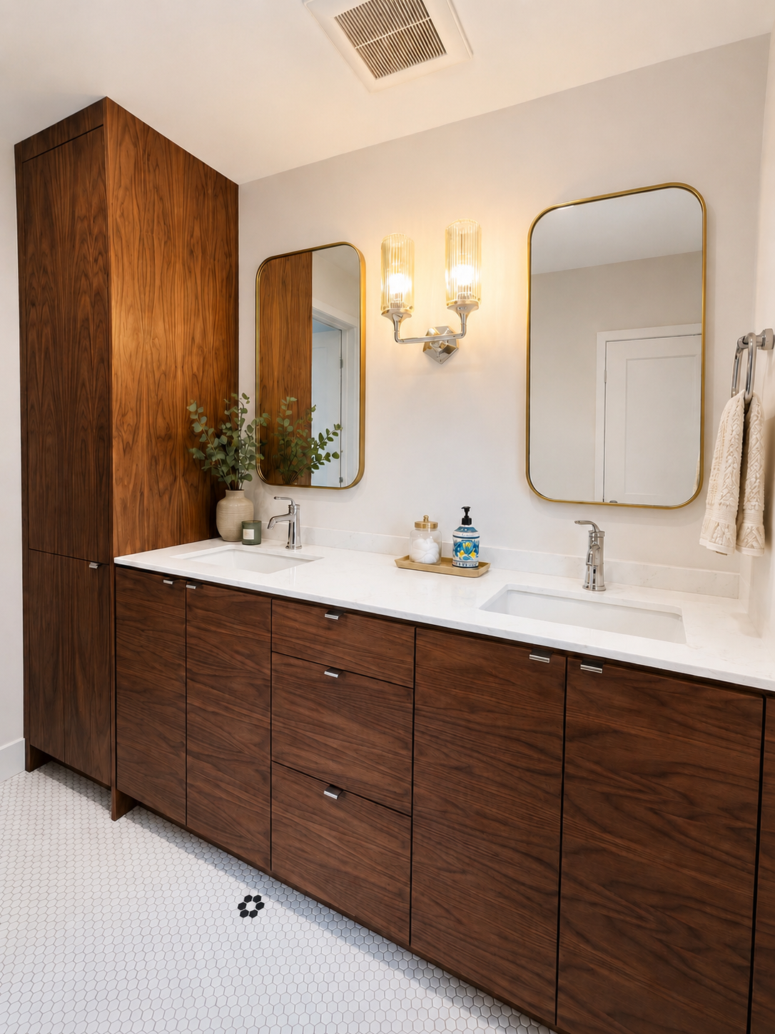 Modern bathroom vanity with wood cabinets, white countertop, double mirrors, and wall sconces
