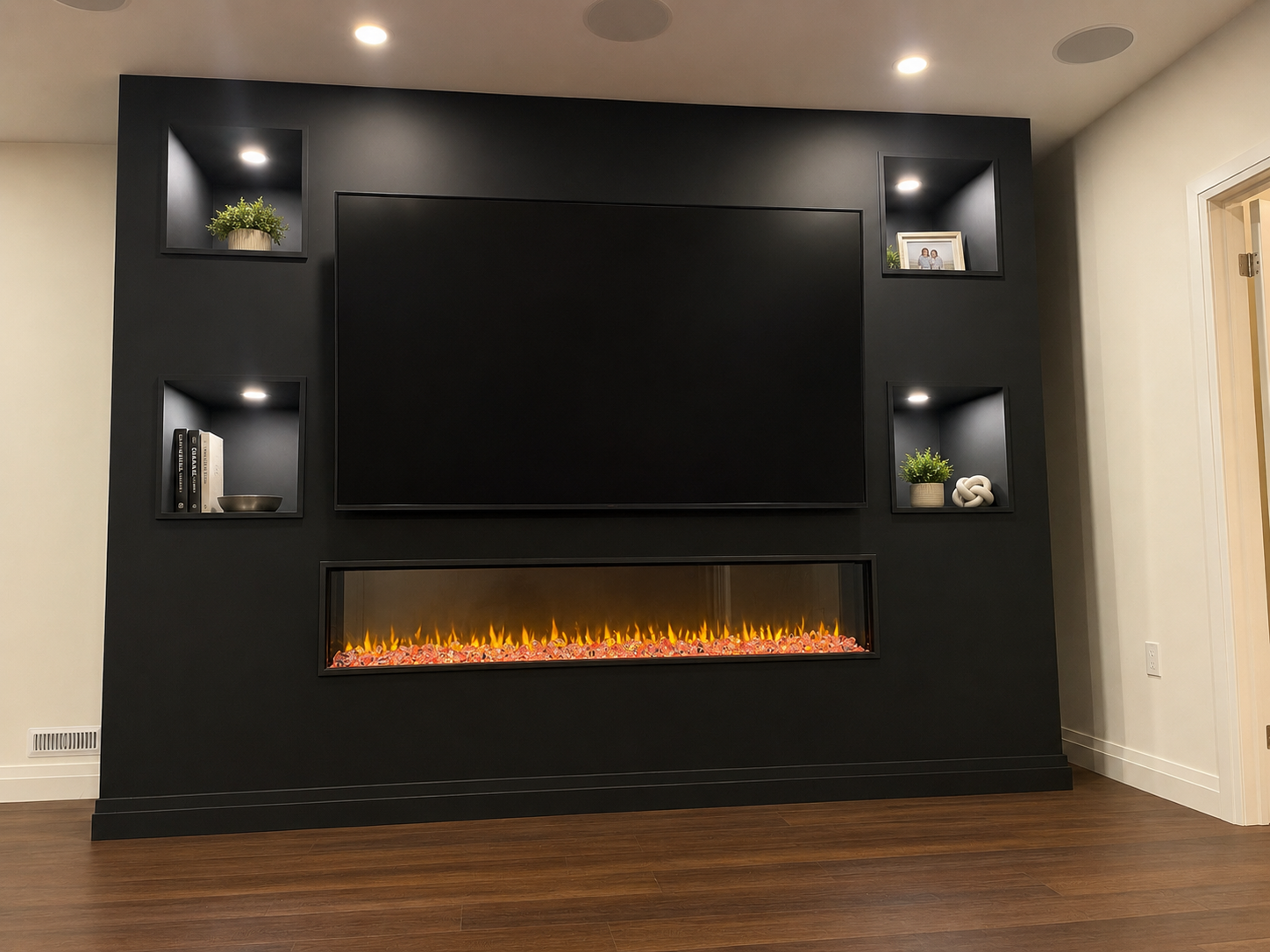 Modern living room wall with large TV above a linear electric fireplace and built-in shelves with decor.