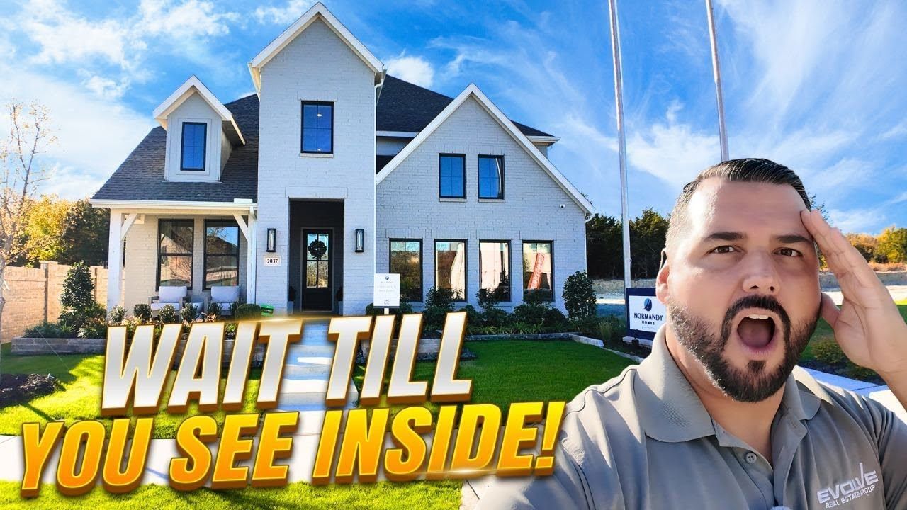 Man gestures excitedly towards a modern two-story house on a sunny day. Text reads:
