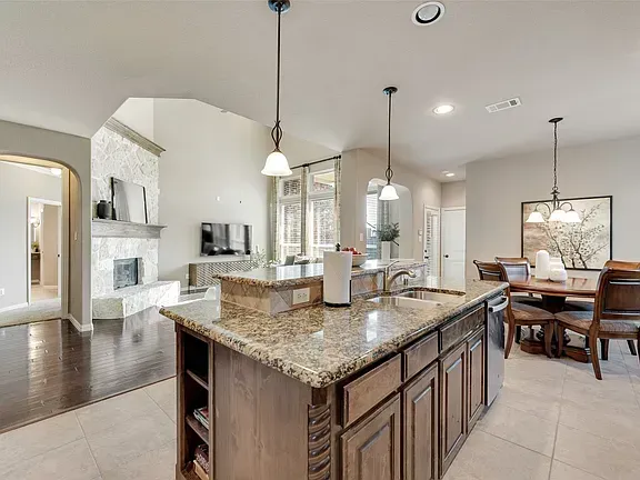 Bright modern kitchen with granite island, white cabinets, and adjoining dining area