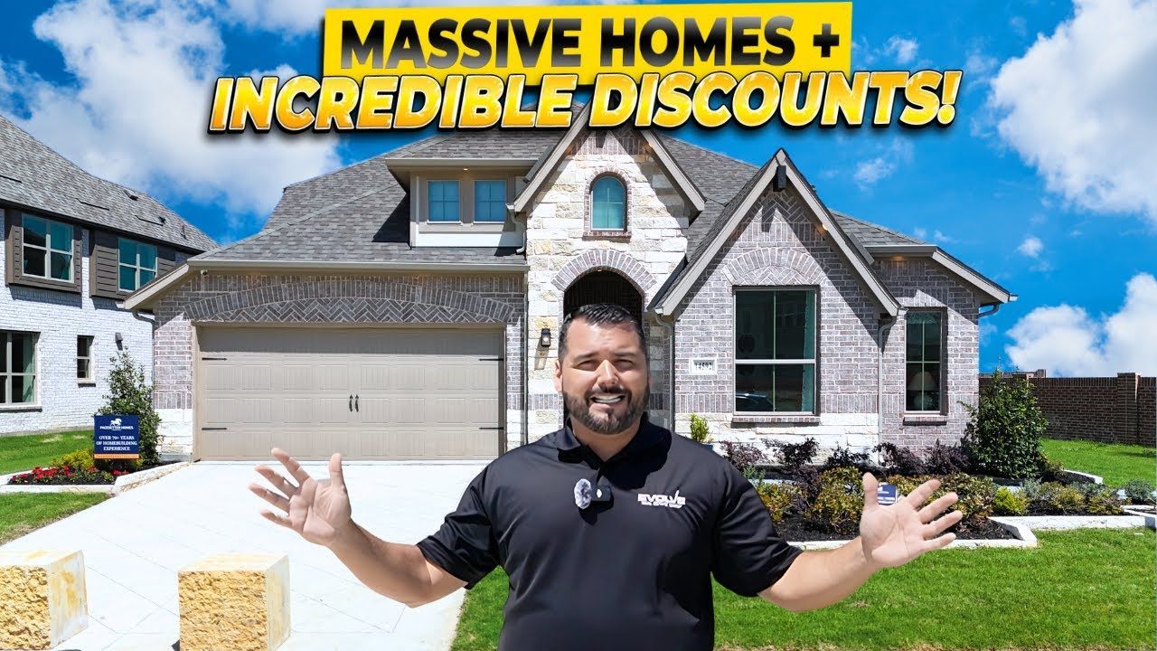 A man is standing in front of a large brick house.