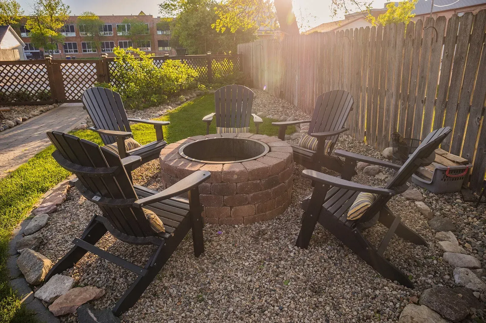 A fire pit with chairs around it in a backyard.