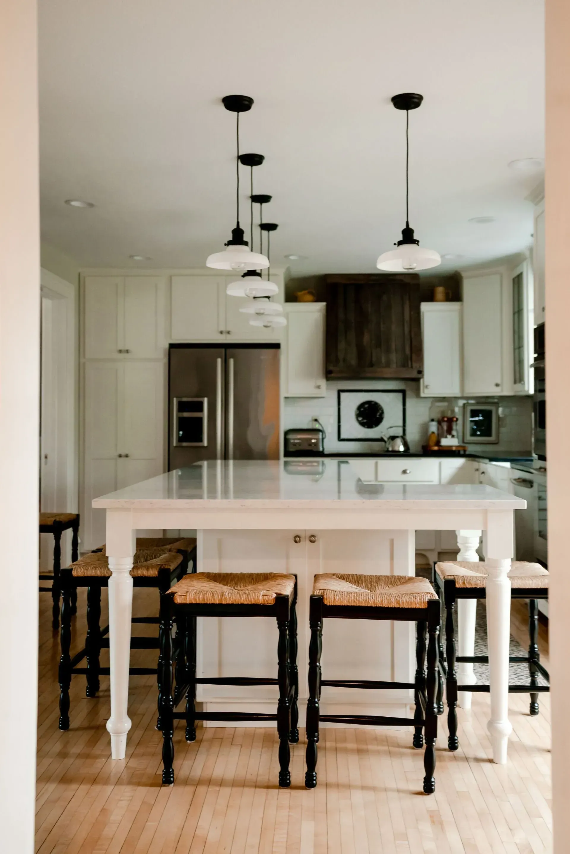 A kitchen with a table and stools in it