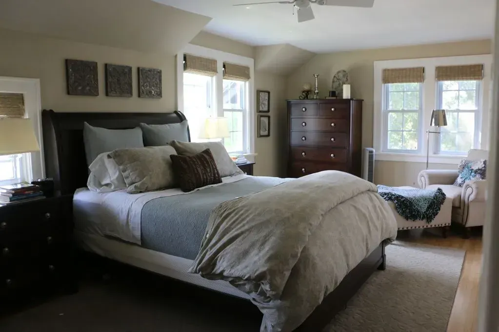 A bedroom with a large bed and a dresser