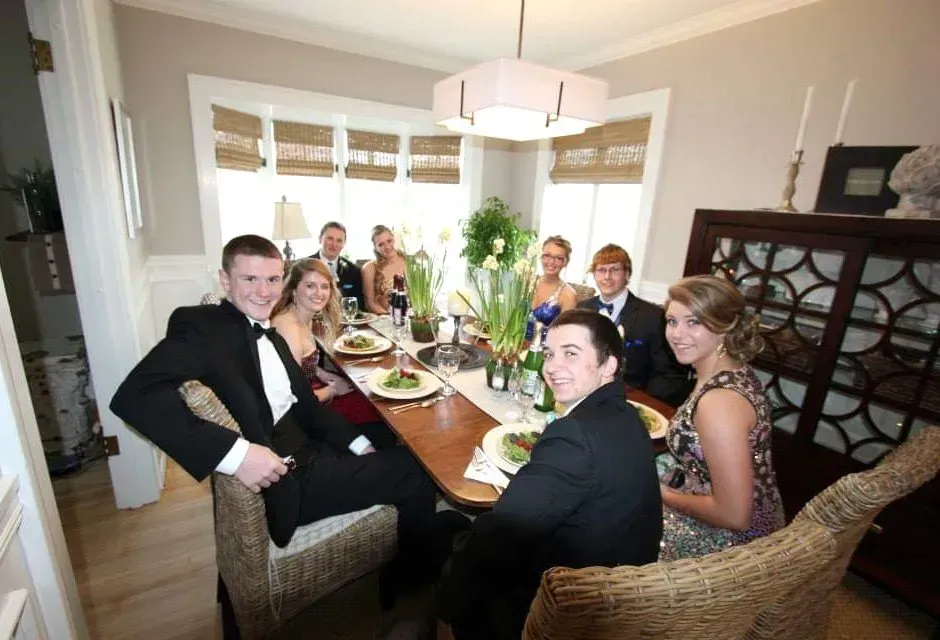 A group of people are sitting around a dining table