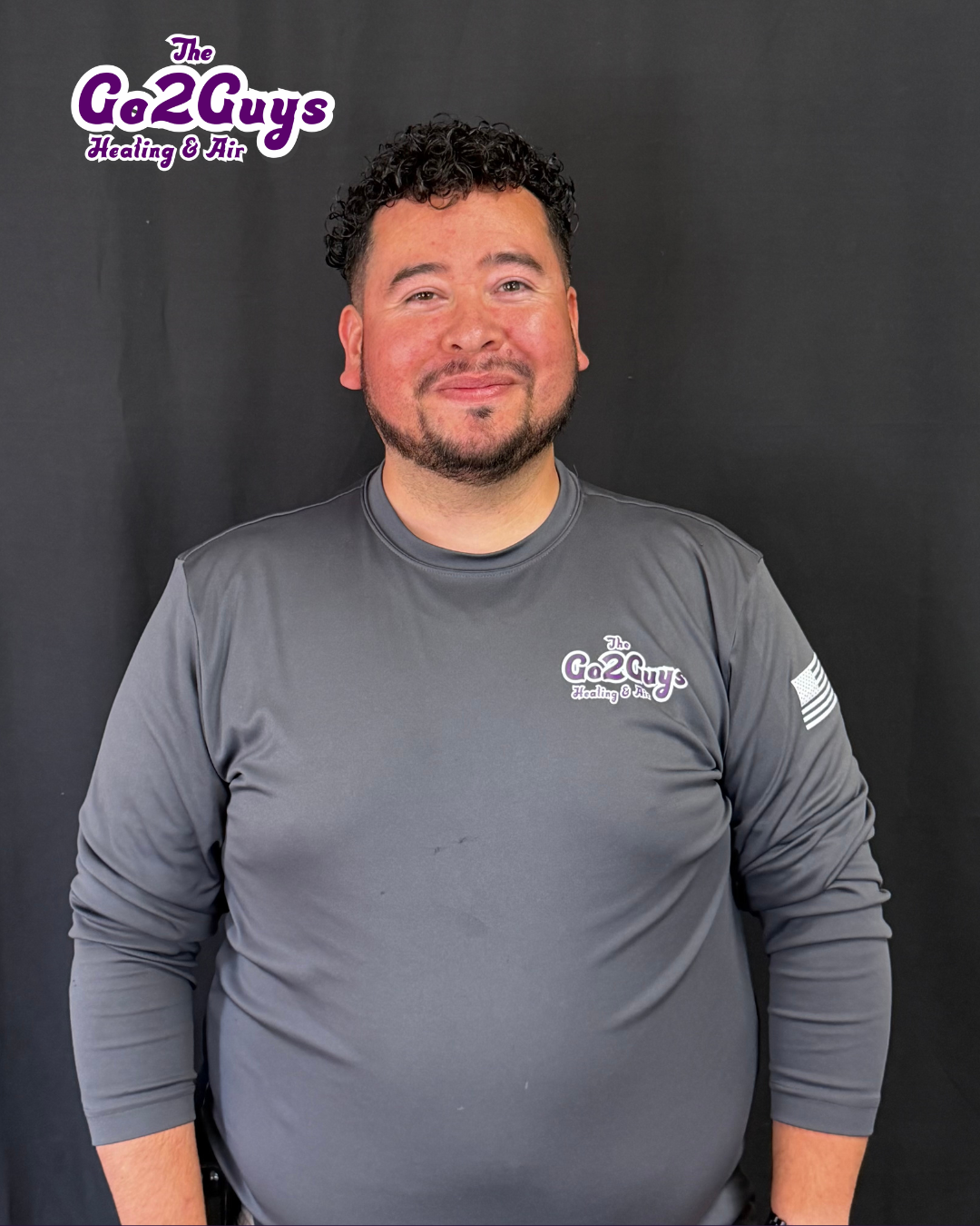 Man in gray long-sleeve shirt posing against a black backdrop with a Ca2Guys logo.