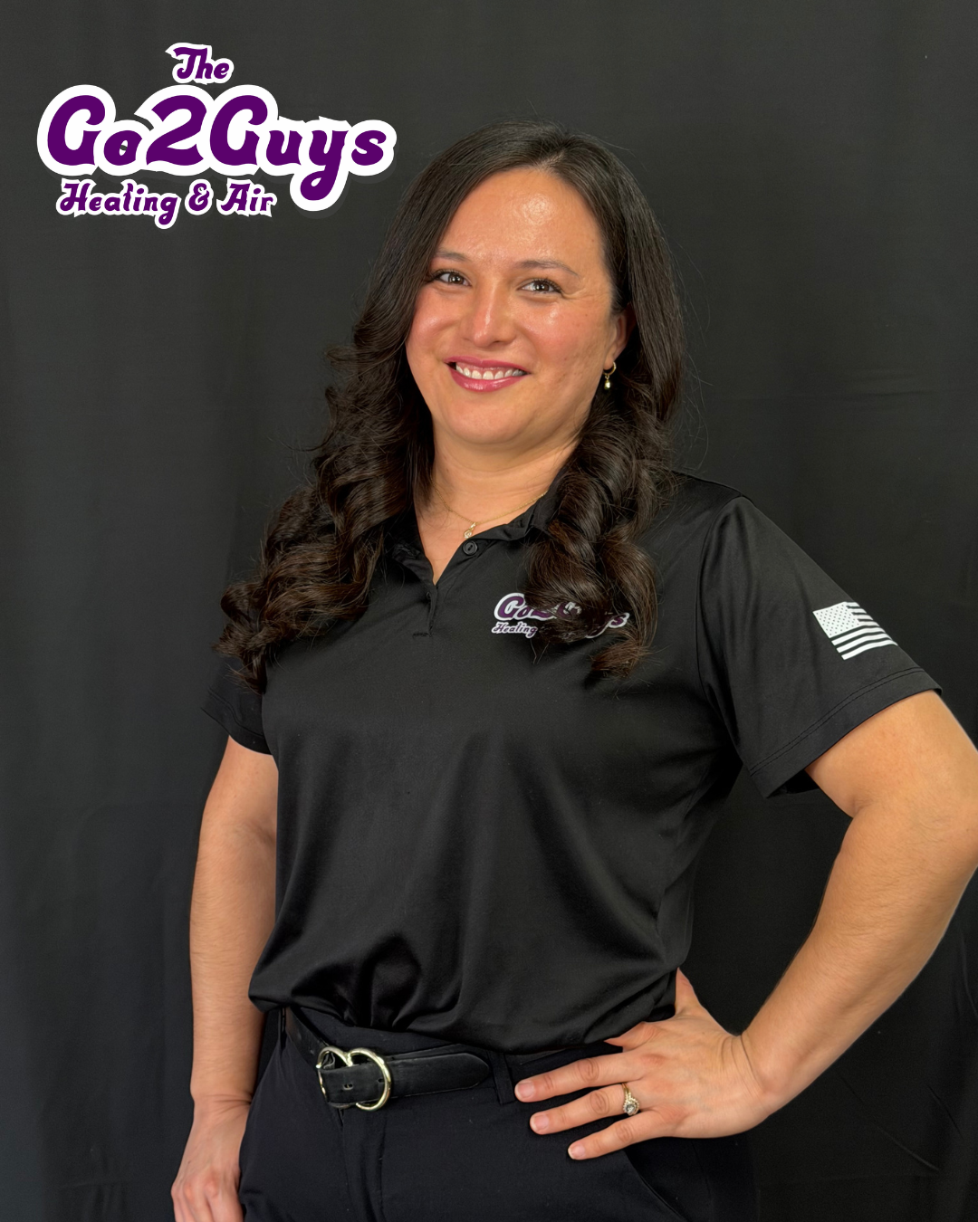 Woman in black polo shirt smiling against a dark background, with “The Ga2Guys” logo in the corner